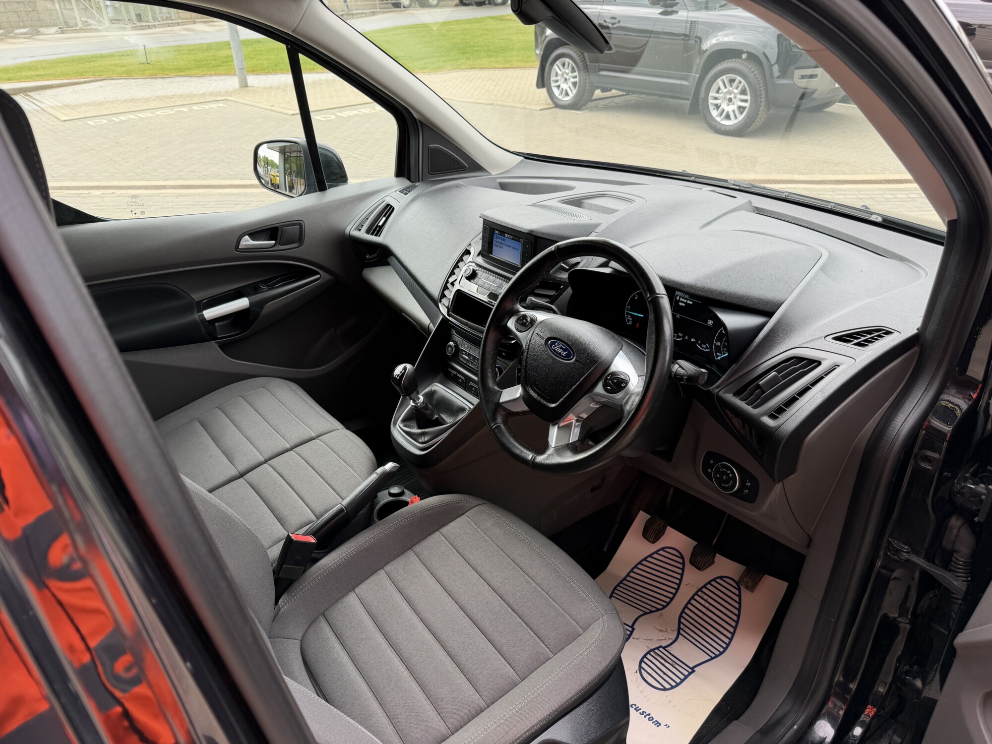 Ford Transit Connect cab interior with grey seats, manual gearbox and dashboard screen